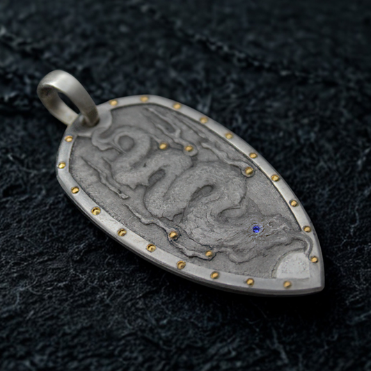 Silver pendant with intricate design on a dark textured background