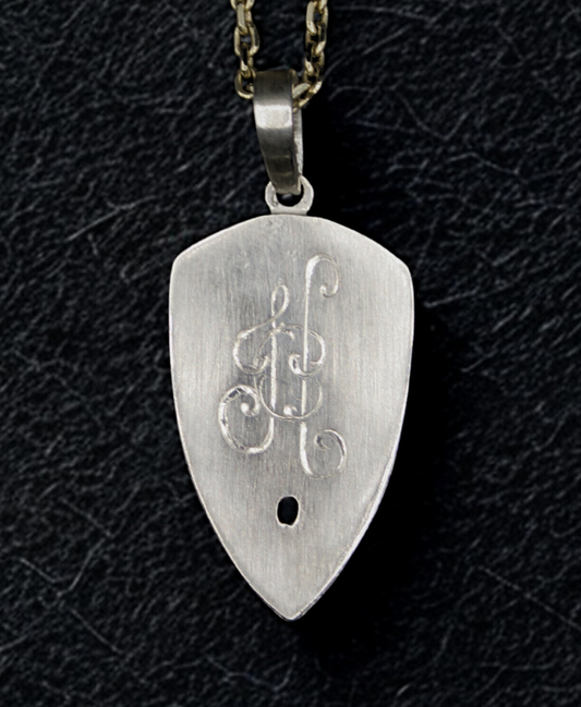 Silver guitar pick-shaped pendant with engravings on a black textured background
