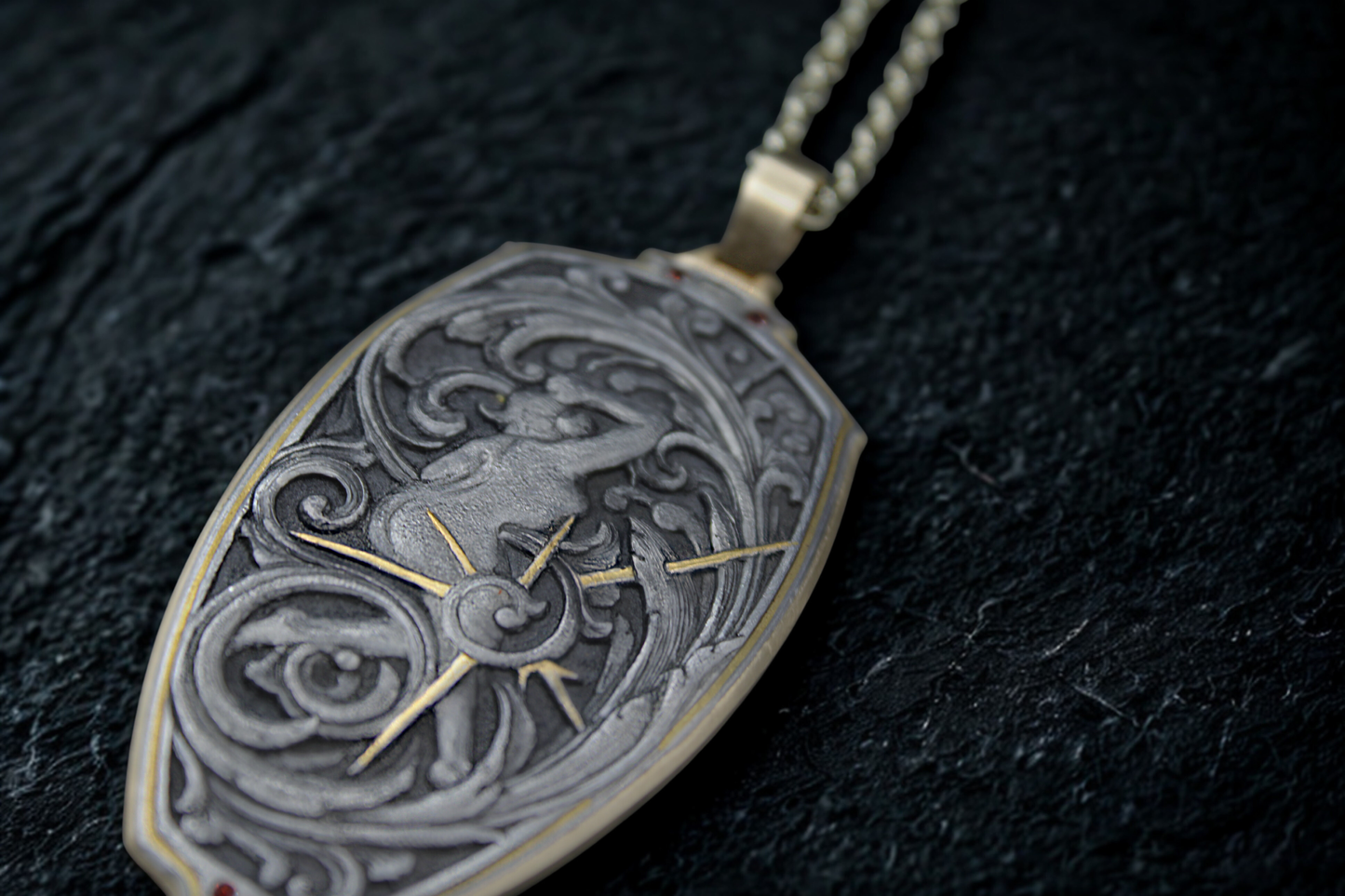 Decorative pendant with intricate designs on a dark surface