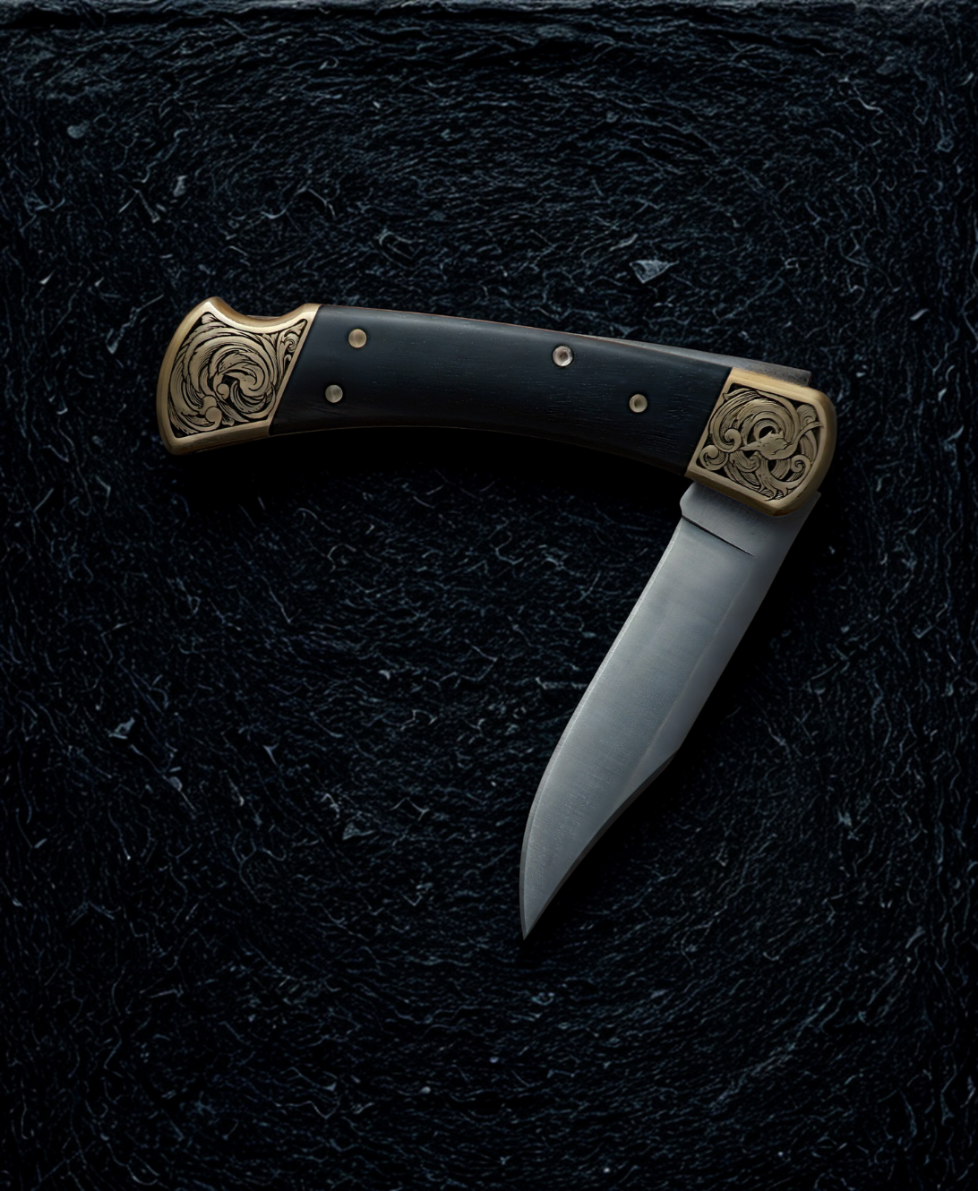 Hand engraved buck 110 folding knife. The engraving features scrollwork. The knife is resting on a dark textured background