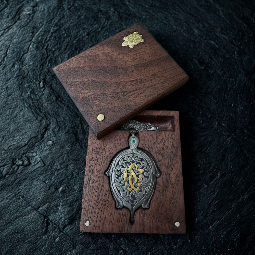 Decorative pendant in a wooden box on a dark stone surface