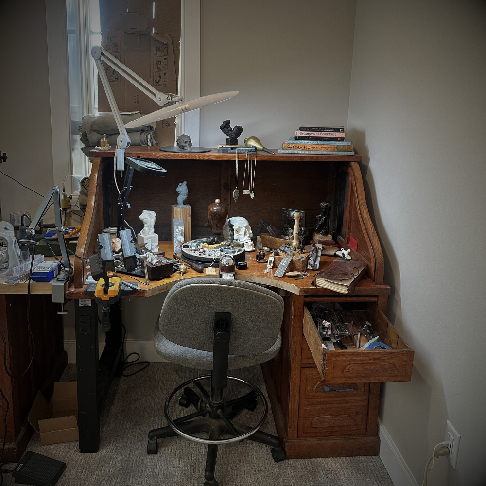 Wooden desk with various items including a chair in a room setting.