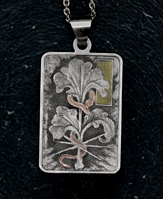 Silver pendant with floral design on a dark background