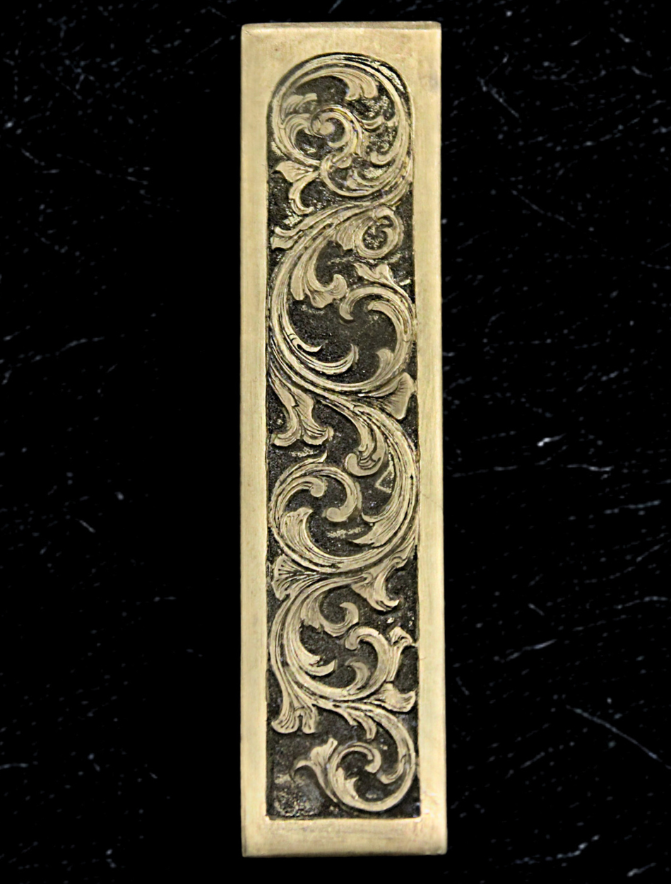Decorative metal handle with intricate patterns on a dark textured background